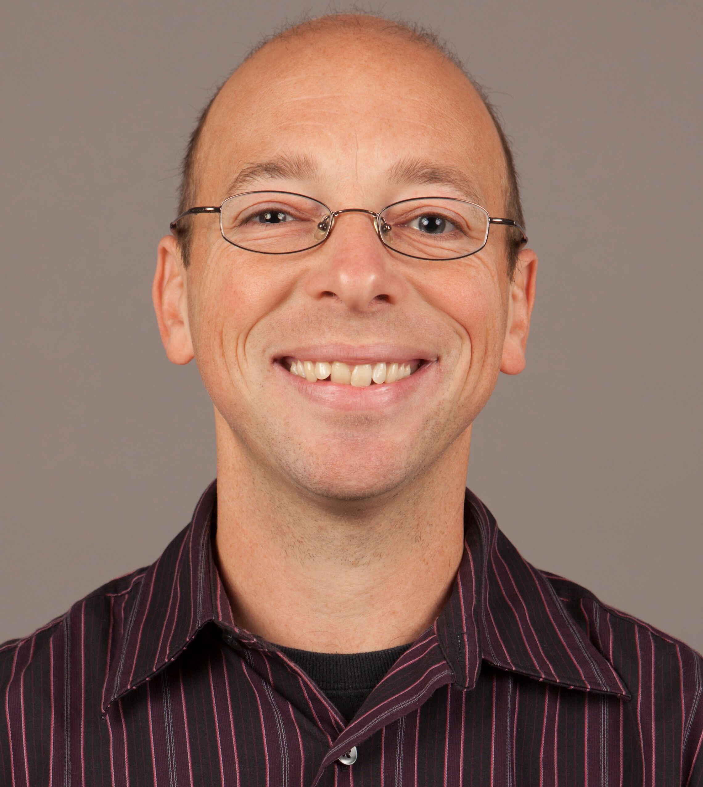 Headshot of a smiling Dr. Asher Newsome