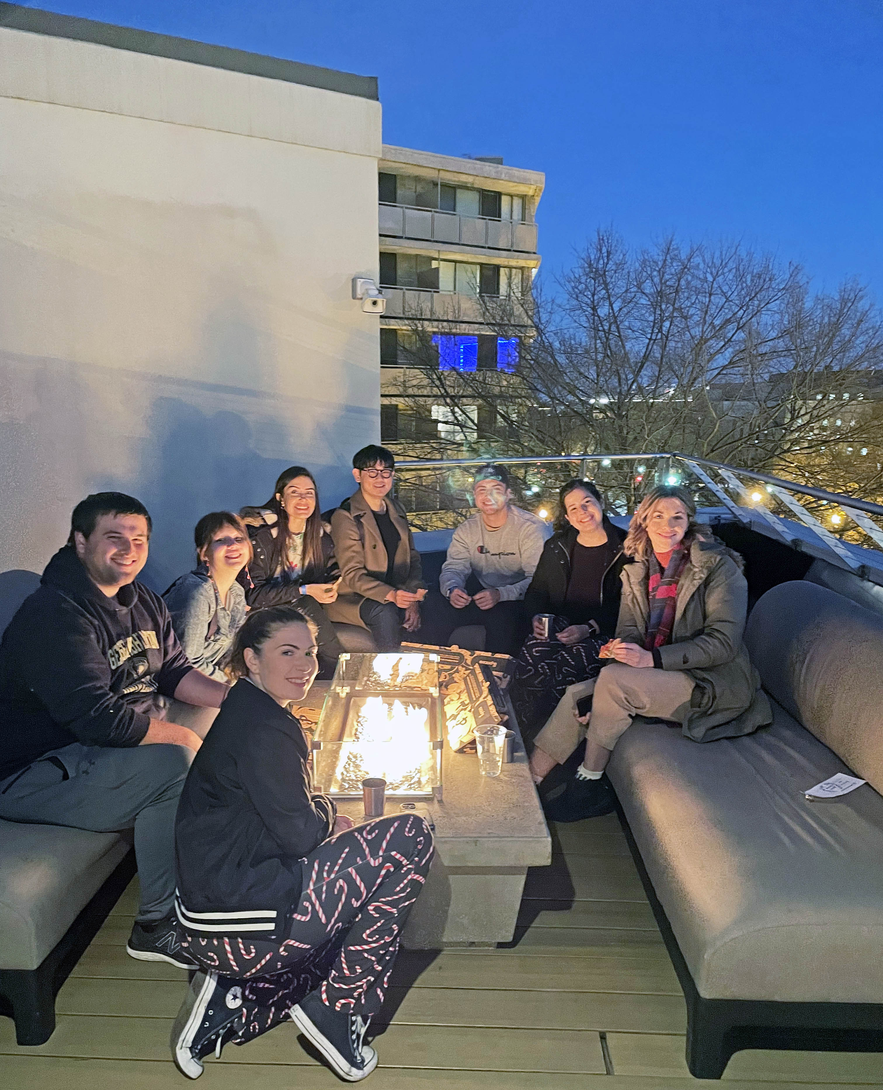 Graduate students around a filre at the holiday party