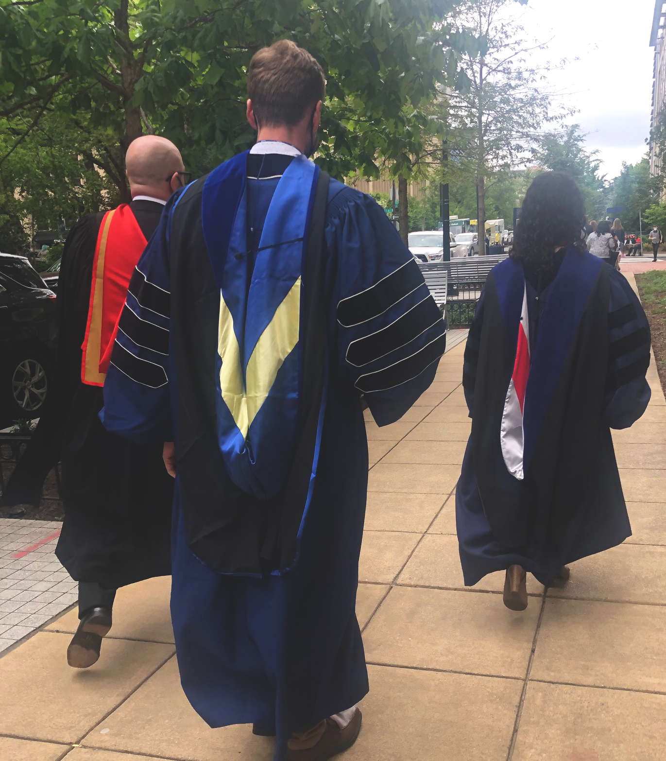 New PhD Dr. Caleb Reese walking to commencement with Drs. Boyes and Voutchkova