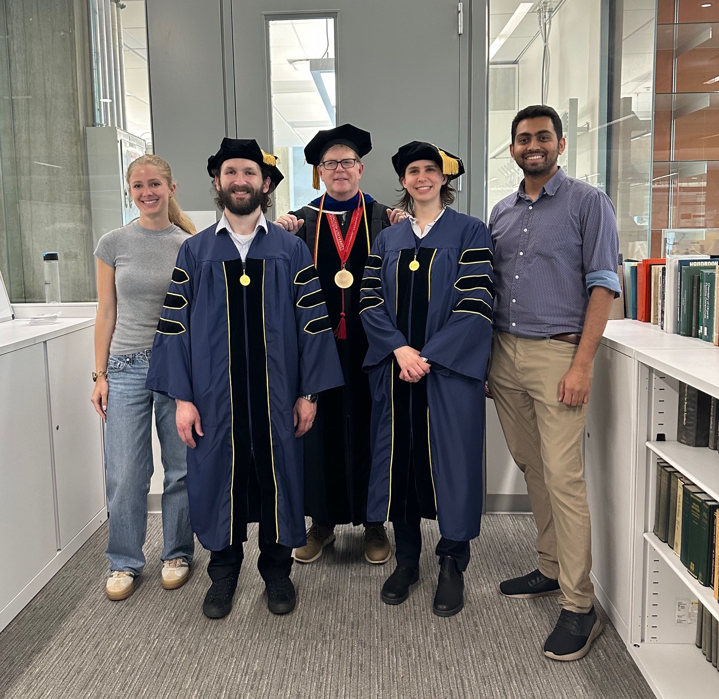 Dr. Cahill's group with he and his graduating PhDs in their regalia