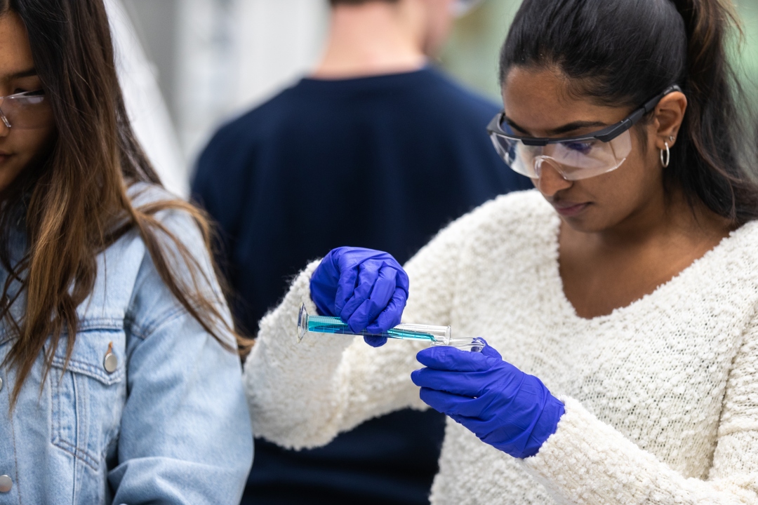 GW Chemistry undergraduate student pouring a liquid