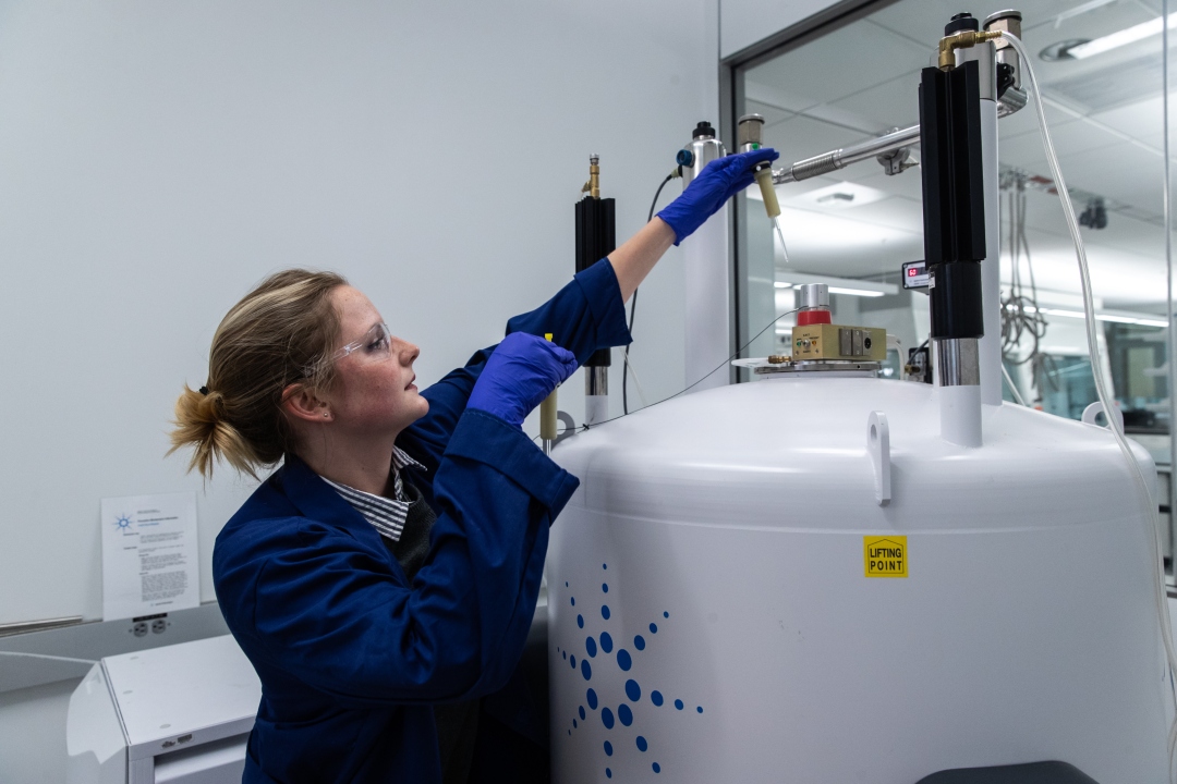 GW Chemistry graduate student from the Voutchkova group using an NMR machine to check the compound of a sample