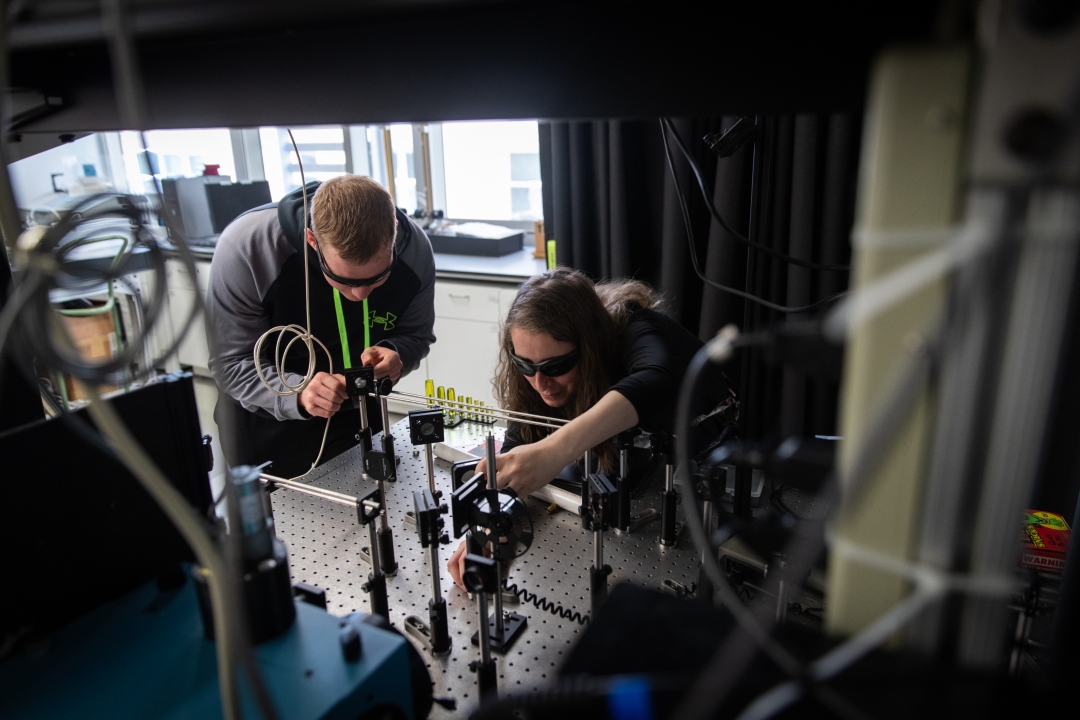 2 Chemistry Graduate students examining equipment