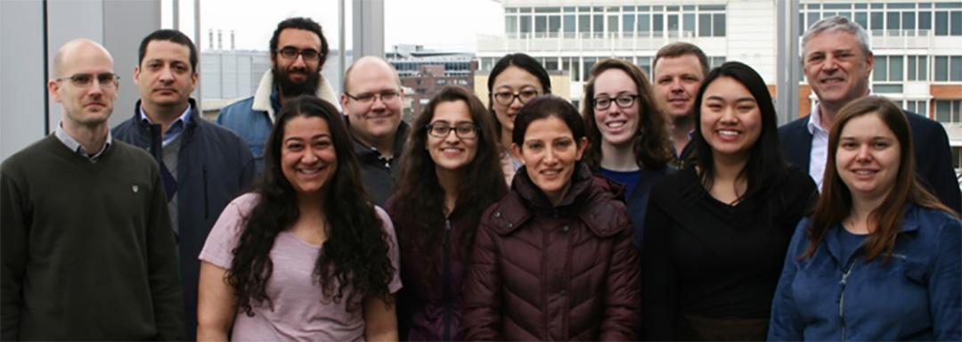 Dr. Akos Vertes with a group of his lab researchers smiling at the camera