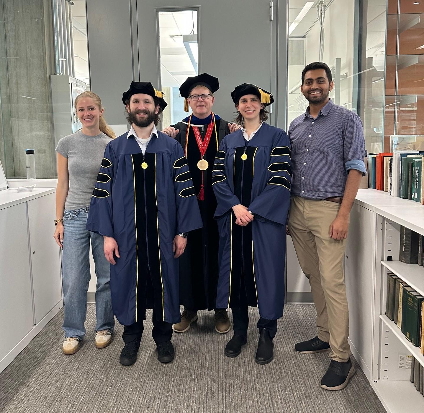 Dr. Cahill's group with he and his graduating PhDs in their regalia