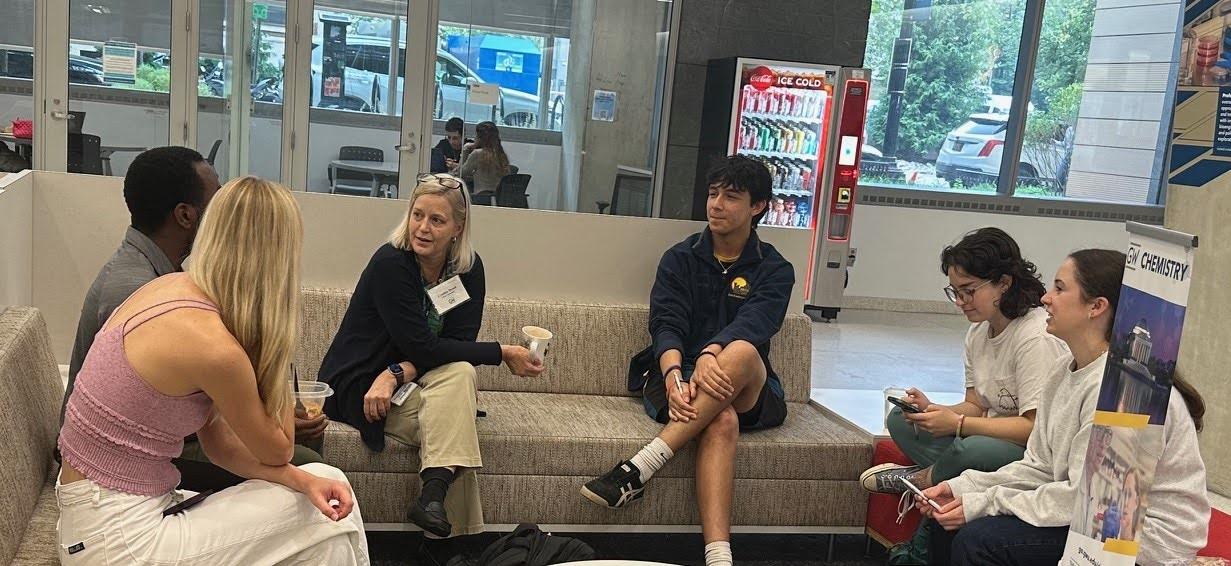 Cindy Dowd and students seated together on chairs arranged in a circle