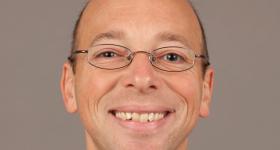 Headshot of a smiling Dr. Asher Newsome