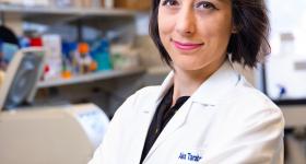 Dr. Taraboletti in a lab coat standing in her lab